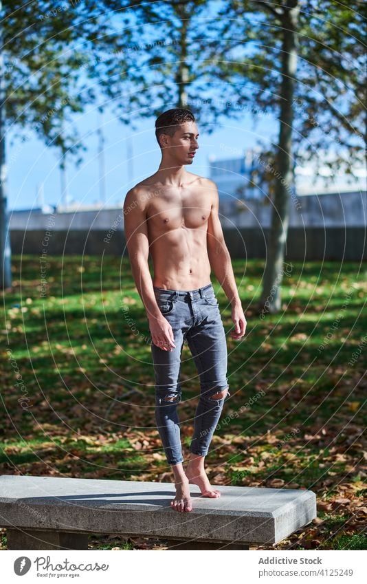 Shirtless fit Mann im Park stehen ohne Hemd selbstbewusst Tänzer Anmut Athlet Bauchmuskeln passen Barfuß nackter Torso Jeanshose Herbst Gesundheit Motivation