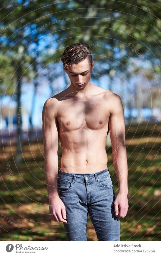 Shirtless fit Mann im Park stehen ohne Hemd selbstbewusst Tänzer Anmut Athlet Bauchmuskeln passen Barfuß nackter Torso Jeanshose Herbst Gesundheit Motivation