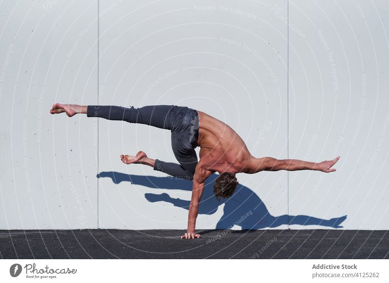 Starker Sportler bei einer Handstandübung Artist ohne Hemd Dehnung Gleichgewicht Single muskulös stark Muskel passen aktiv Körper Rücken angewinkelt Knie