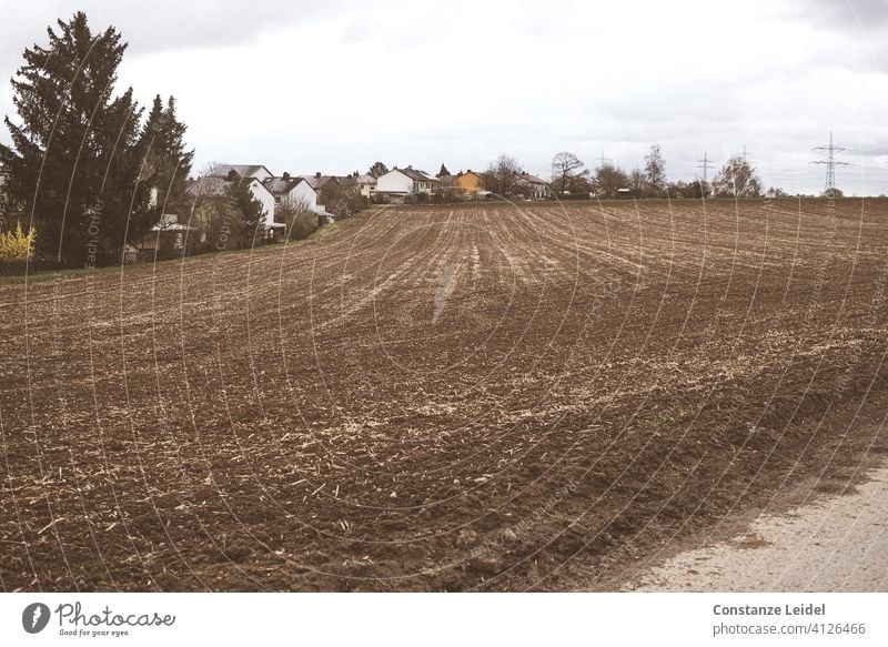 Stadtrand mit Ackerfläche Ackerbau Ackerland Ackerlandschaft Feld Natur ländlich Land Landschaft natürlich Ernte Himmel Landwirtschaft landwirtschaftlich braun