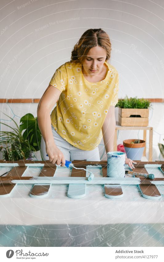 Junges Mädchen malt einen Zaun Fähigkeit Handwerk Gerät Farbe Malerei Bürste Kaukasier Konstruktion Handwerkerin diy es selbst machen Frau blond Möbel