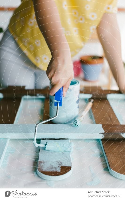 Nahaufnahme eines Farbrollers mit blauer Farbe Zaun Fähigkeit Handwerk Gerät Malerei Bürste Kaukasier Konstruktion Handwerkerin diy es selbst machen Frau blond