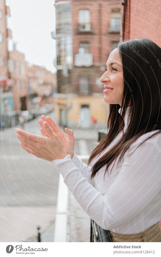 Junge Frau applaudiert Ärzten, die auf dem Balkon stehen Coronavirus applaudieren Klatschen abstützen positiv COVID Pandemie jung medizinisch Ausbruch Hoffnung