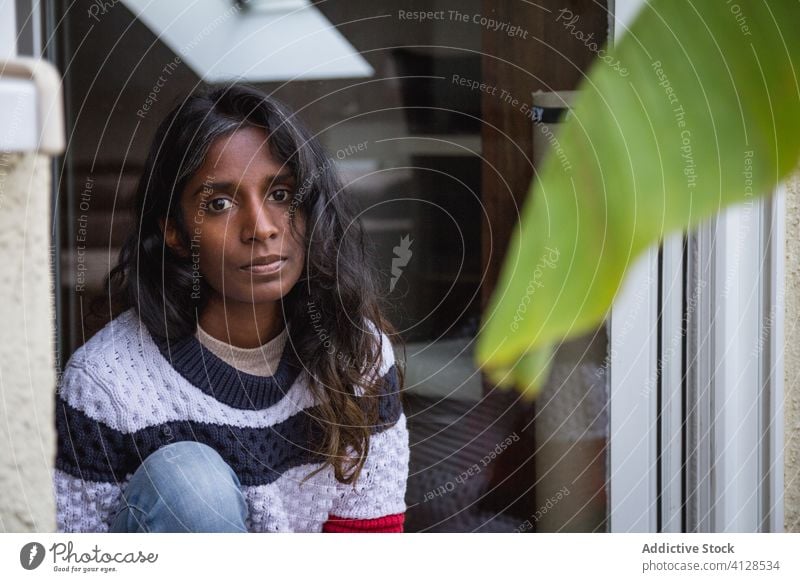 Indische Frau entspannt sich auf dem Balkon sich[Akk] entspannen Terrasse Wochenende genießen lässig Outfit ethnisch Inder hinduistisch Bekleidung anhaben