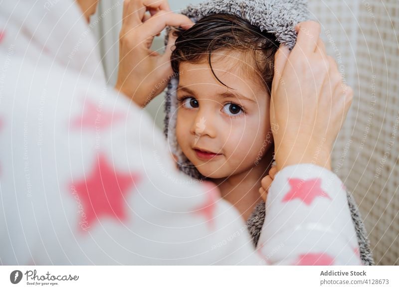 Erfreute Mutter und Sohn nach der Dusche im Badezimmer kuscheln Freude Bademantel Junge wenig Kind Lächeln Inhalt nasses Haar bezaubernd Umarmen Handtuch Turban