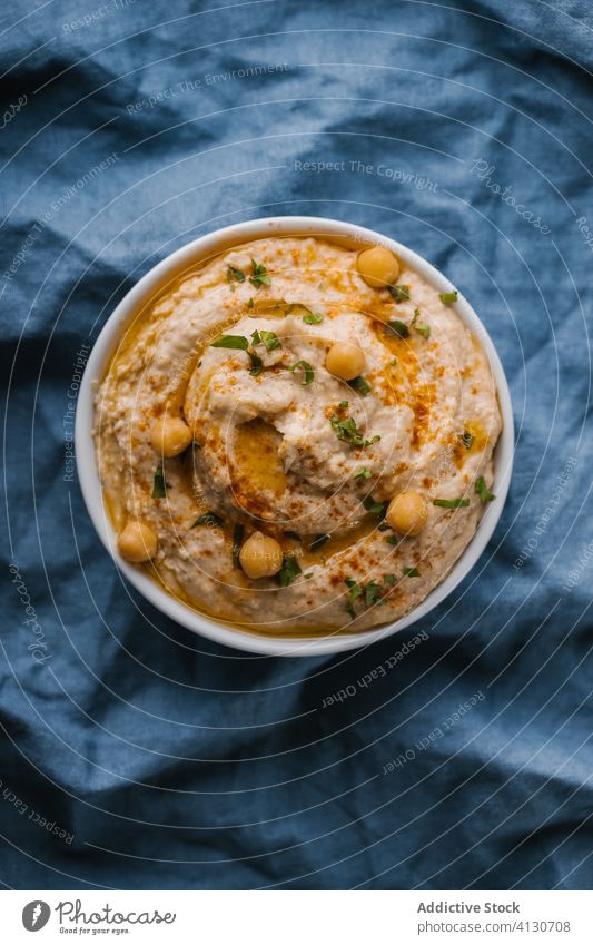 Hausgemachter Hummus auf blauem Hintergrund Amuse-Gueule Schalen & Schüsseln Brot Kichererbsen cremig Dip Lebensmittel Gesundheit selbstgemacht Mittagessen