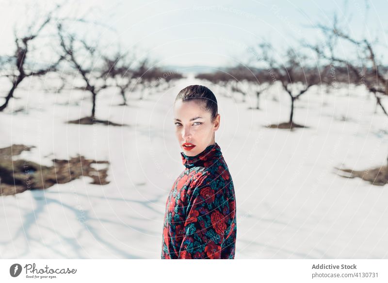 Selbstbewusste trendige Frau steht im verschneiten Feld Stil trendy selbstbewusst Schnee Natur attraktiv modern Mode charmant ernst farbenfroh trotzig jung