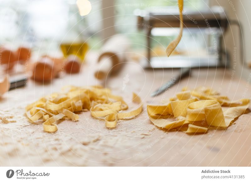 Unordentlicher Tisch mit Nudelzutaten und Kochzubehör auf Mehl Spätzle roh selbstgemacht Bestandteil unordentlich Eierschale Küchengeräte Utensil Kochen