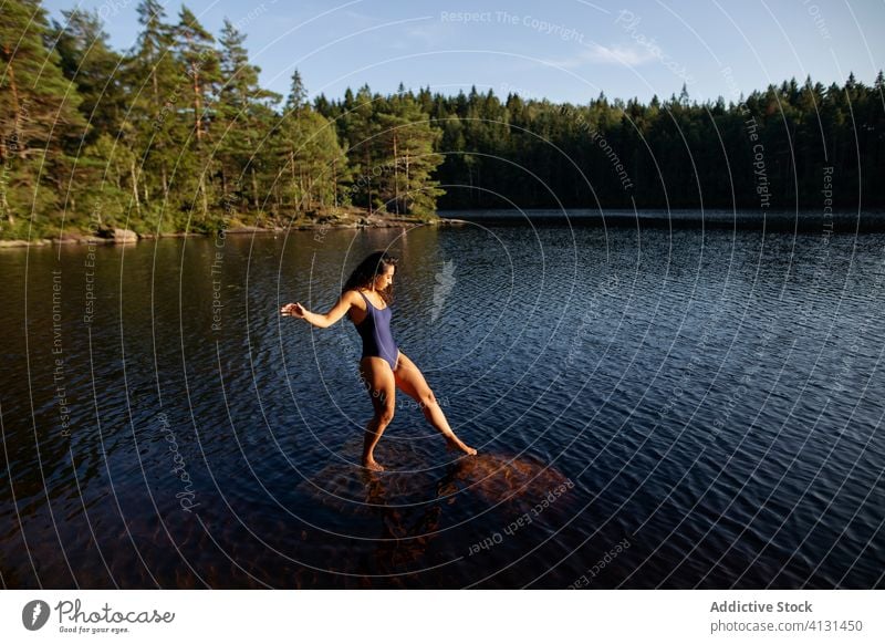 Frau im Badeanzug im See stehend Wasser Windstille Sonnenuntergang genießen Sommer majestätisch Landschaft Wald ruhig Gelassenheit Harmonie friedlich idyllisch