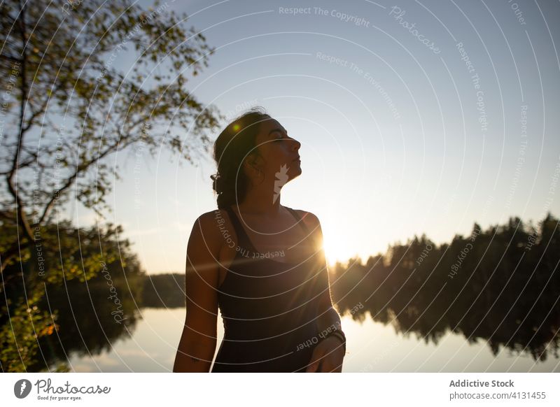 Gelassene Frau, die sich im Urlaub am See entspannt sich[Akk] entspannen Sonnenuntergang Windstille Landschaft prunkvoll Wald genießen Wasser Gelassenheit ruhig