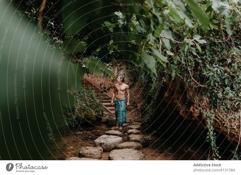 Mann in traditioneller Hose beim Waldspaziergang Sprit Natur Tradition ethnisch Baum Garten ohne Hemd männlich muskulös nackter Torso Barfuß Harmonie ruhig