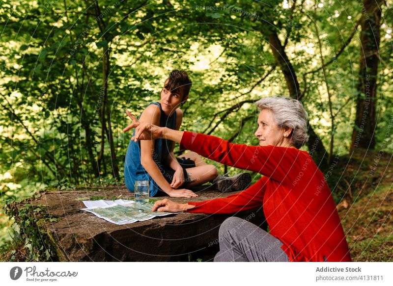 Reisende Frauen wählen die Route mit Karte und Kompass navigieren Wald Landkarte reisen sich orientieren diskutieren Örtlichkeit Senior Zeigen jung Zusammensein