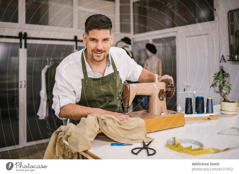 Glücklicher Mann Schneiderin Nähen Outfit mit Maschine in modernen komfortablen Atelier nähen Handwerk Damenschneiderin Kleidung kreativ handgefertigt Werkzeug