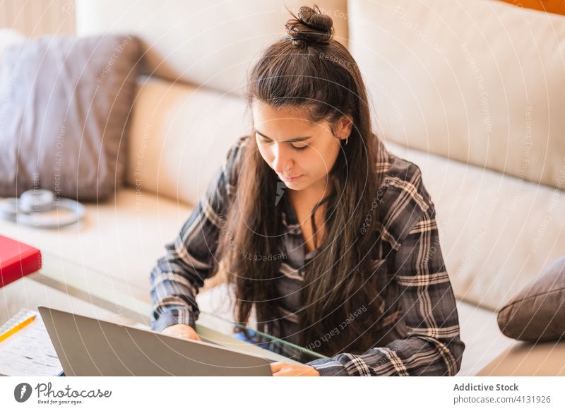 Junge Frau arbeitet mit Laptop im Wohnzimmer heimwärts benutzend Arbeit freiberuflich Sofa jung lässig abgelegen Gerät Apparatur Browsen Internet Lifestyle