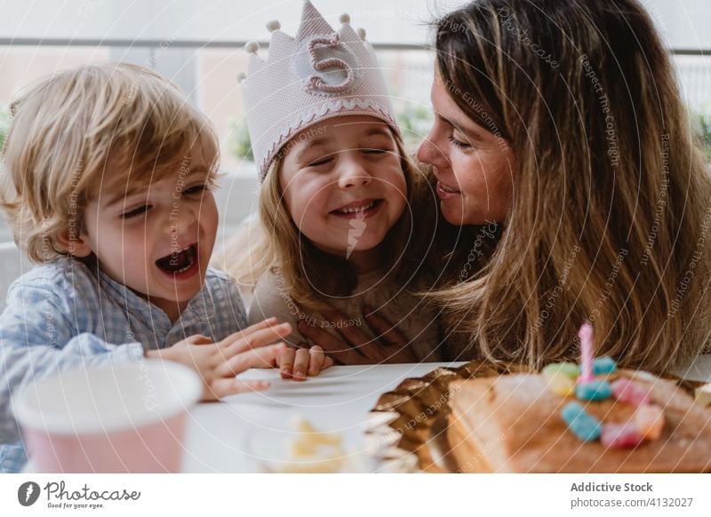 Glückliche Mutter und Junge mit Geburtstagsparty Mädchen Bruder feiern Kuss Zusammensein Sohn wenig Party aufgeregt heimwärts Kind Tisch positiv Eltern