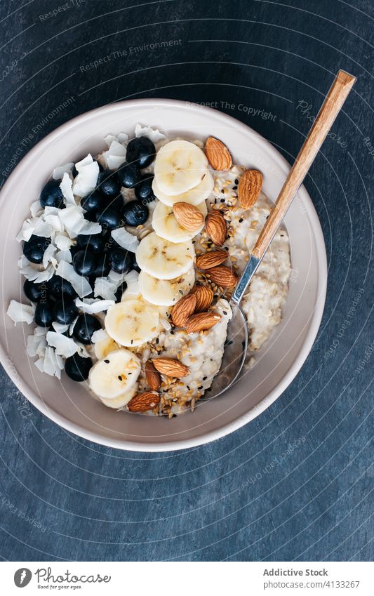 Schale mit Haferbrei Blaubeeren Mandeln Banane Kokosnuss Saatgut Löffel Korn Frucht Haferflocken Lebensmittel Frühstück Schalen & Schüsseln Gesundheit Müsli