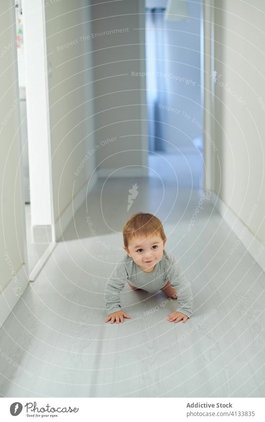 Glückliches Baby krabbelt auf dem Boden krabbeln Stock niedlich Lächeln heimwärts Kleinkind Kind Kindheit heiter Freude Lifestyle süß Entwicklung erkunden