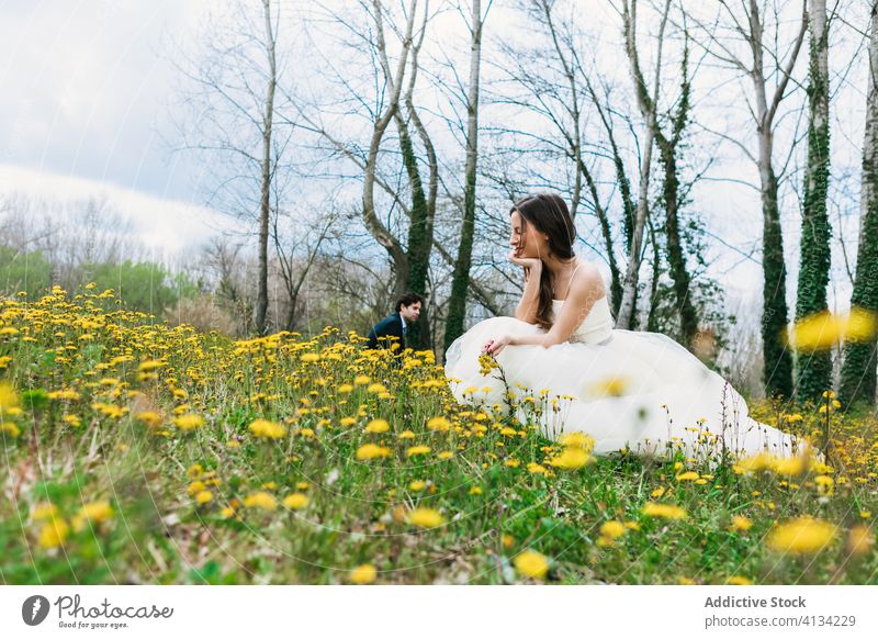 Zufriedene Braut auf blühender Wiese mit gelbem Löwenzahn Blüte Jungvermählter Hochzeit Brautkleid Blume grün Hochzeitstag Frau Blütezeit traumhaft Gras