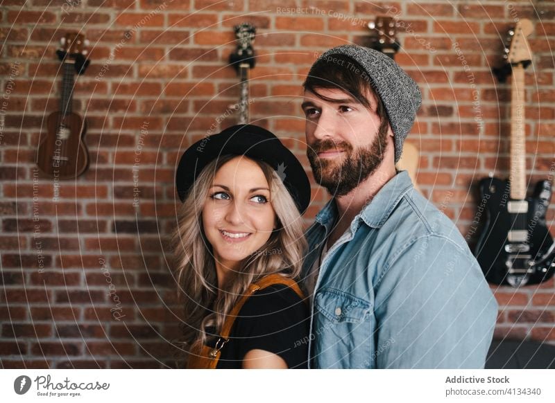 Paar umarmt sich auf dem Sofa in der Wohnung Umarmen Kuss Hipster Loft Partnerschaft Liebe Innenbereich Musiker Freund Zuneigung Zusammensein Freundin bequem