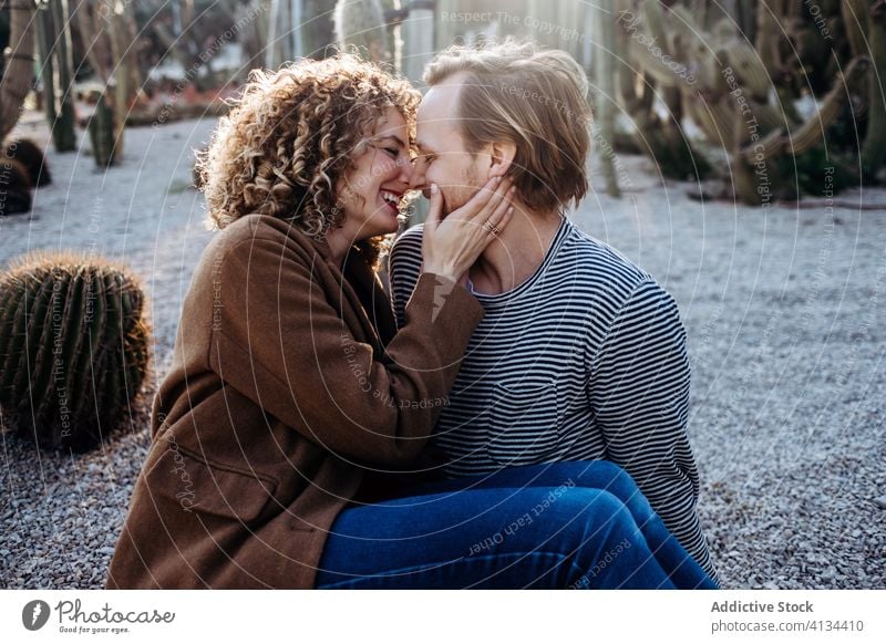 Glückliches Paar umarmt sich im Kaktuspark Umarmung Liebe Park sonnig tagsüber Barcelona Spanien Mann Frau aufgeregt Partnerschaft Umarmen heiter Sommer