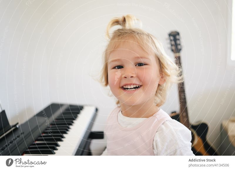 Süßes Mädchen lernt modernes Klavierspielen lernen heimwärts Synthesizer Kindheit niedlich Musik Glück Lächeln Klasse Rock Schulmädchen Bildung üben vorbereiten