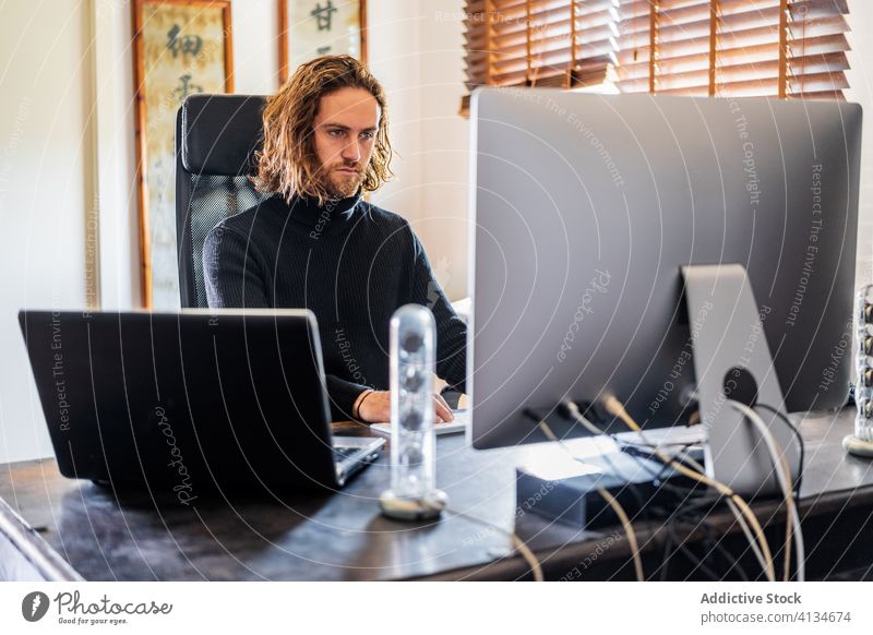 Hübscher Mann arbeitet zu Hause am Desktop-Computer Tippen Keyboard freiberuflich heimwärts abgelegen Arbeit benutzend männlich ernst Projekt beschäftigt