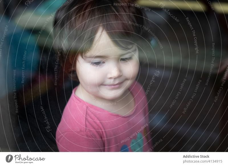 Kind steht am Fenster heimwärts Mädchen einsam nachdenklich besinnlich Windstille Kindheit ruhig Einsamkeit allein Quarantäne Selbstisolierung