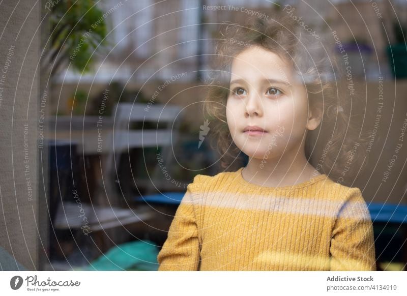 Nachdenkliches Kind schaut aus dem Fenster heimwärts besinnlich nachdenklich träumen Mädchen Vorstellungskraft Denken allein verfehlen einsam Quarantäne