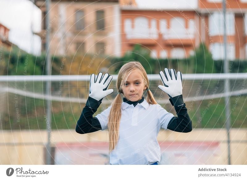 Fokussierte junge Torhüterin wartet auf Ball auf grünem Fußballplatz in Sportverein Mädchen Torwart Spieler wehren Training ernst Stadion Feld spielen warten