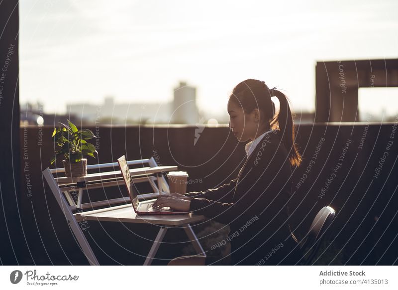 Geschäftige Frau mit Laptop arbeitet auf dem Dach Arbeit benutzend Geschäftsfrau formal Dachterrasse Gerät Apparatur Business asiatisch jung Internet