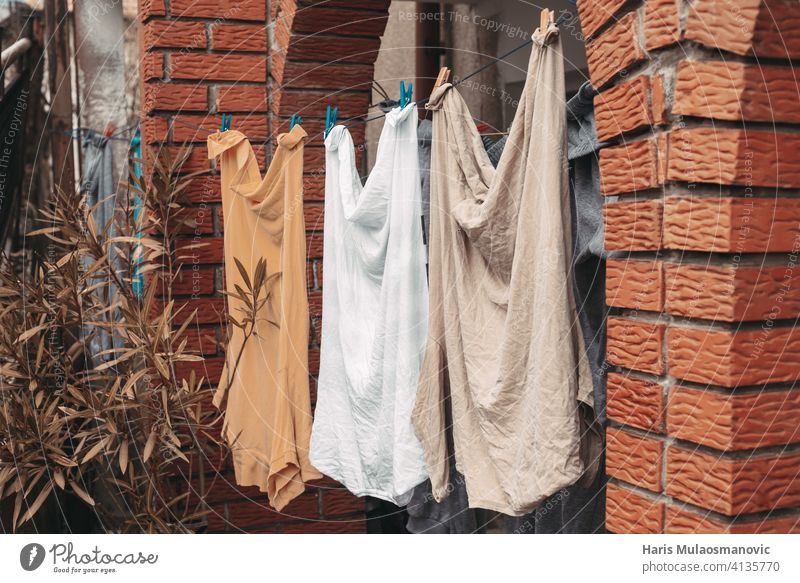 gewaschene Kleidung Männerhemden hängen vor dem Haus orange gelb Pastell Baby Säuglingsalter Hintergrund blau Kinderbetreuung Kindheit Sauberkeit Stoff