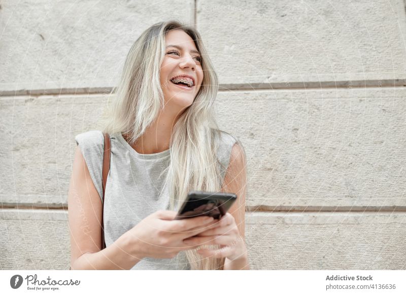 Frau mit Smartphone auf der Straße stehend Großstadt benutzend jung Glück Stil Nachricht Browsen Handy Lifestyle Gerät Apparatur urban Lächeln trendy