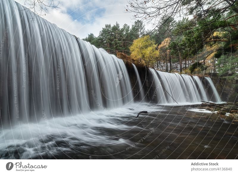 Wunderschöner Wasserfall im Herbstwald Fluss Wald strömen fließen Landschaft felsig wolkig trist malerisch reißend Natur Baum Umwelt fallen wild Laubwerk