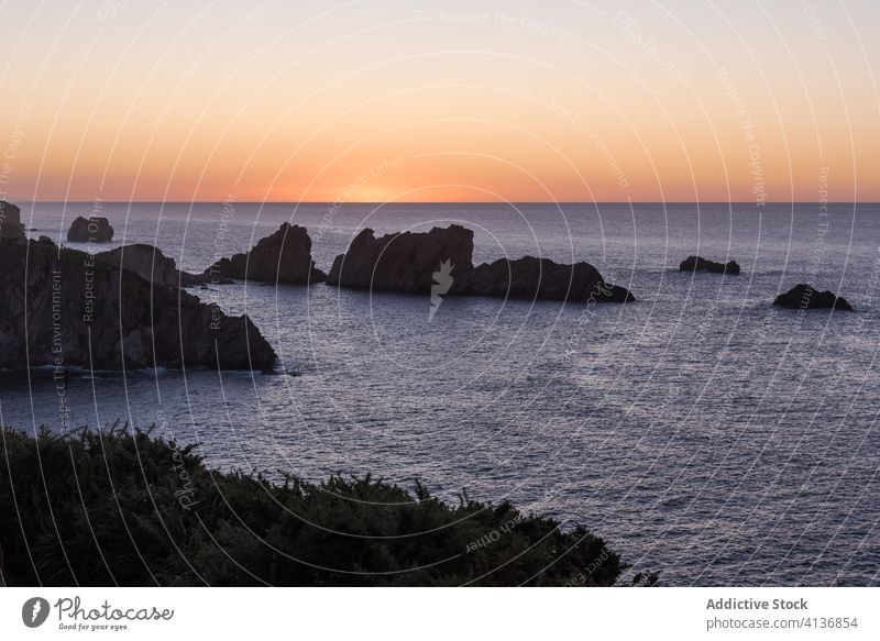 Roter Sonnenuntergang über felsigem Meeresufer MEER Felsen Himmel farbenfroh rot Natur Landschaft ruhig Windstille Dämmerung Abenddämmerung Wasser dunkel