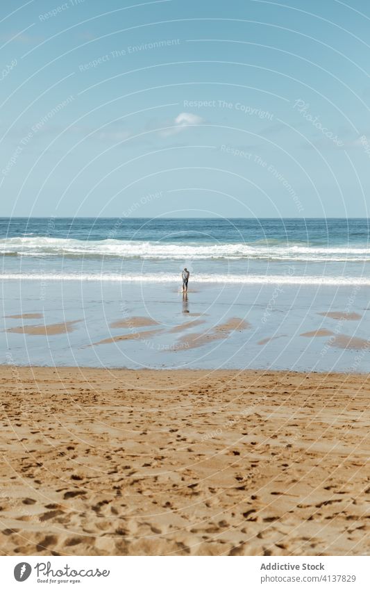 Unbekannter Tourist steht am Sandstrand unter blauem Himmel MEER Strand Fußspur Uferlinie spektakulär Harmonie idyllisch Meereslandschaft Horizont Landschaft