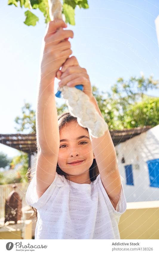 Glückliches Kind schwingt an einem Seil im Garten pendeln aufgeregt Mädchen Spaß haben Sommer Urlaub Feiertag Aktivität heiter Kindheit Freude Freizeit