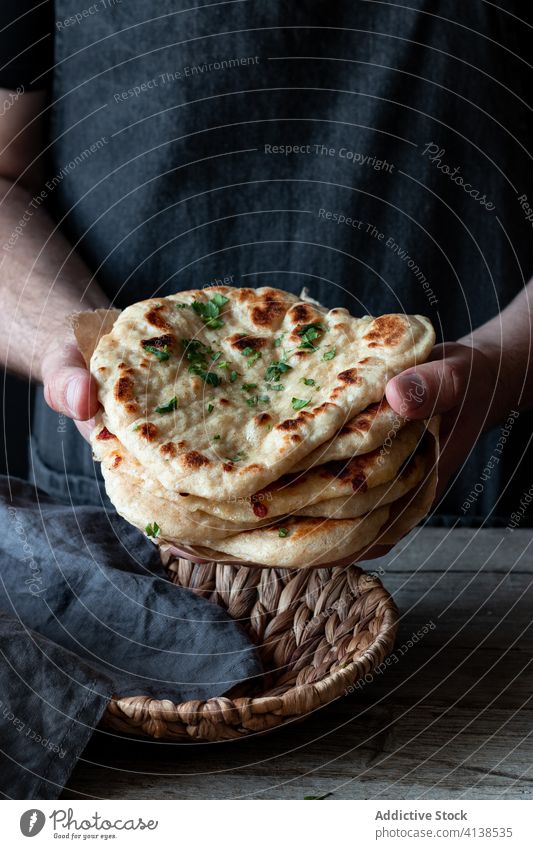 Männlicher Koch mit Naan-Brot am Tisch Bäcker Tradition Mann frisch gebacken Bäckerei Kraut männlich Schürze Indisches Essen Küche Feinschmecker Küchenchef