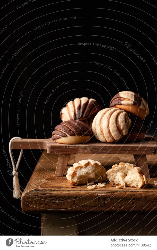 Süße mexikanische Conchas auf einem Schneidebrett Nasenmuscheln Brot Brötchen gebacken süß Dessert lecker hölzern Kultur Tradition mexikanisches Essen rollen