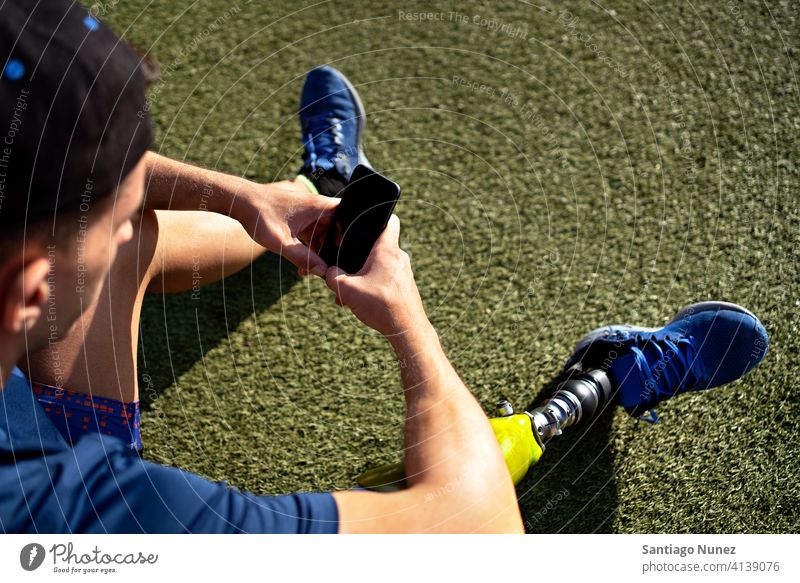 Behinderter Sportler beim Telefonieren per Telefon Mann Läufer Athlet unerkannt gesichtslos Prothesen Prothetik Behinderung deaktiviert Amputation Amputierte