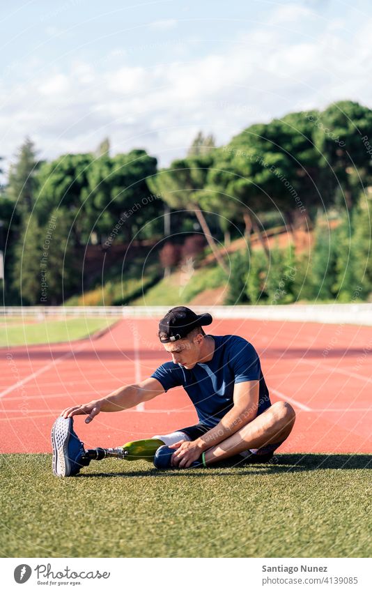 Behinderter Mann, Sportler mit Beinprothese beim Dehnen. Läufer strecken Dehnung Athlet Prothesen Prothetik Behinderung deaktiviert Amputation Amputierte