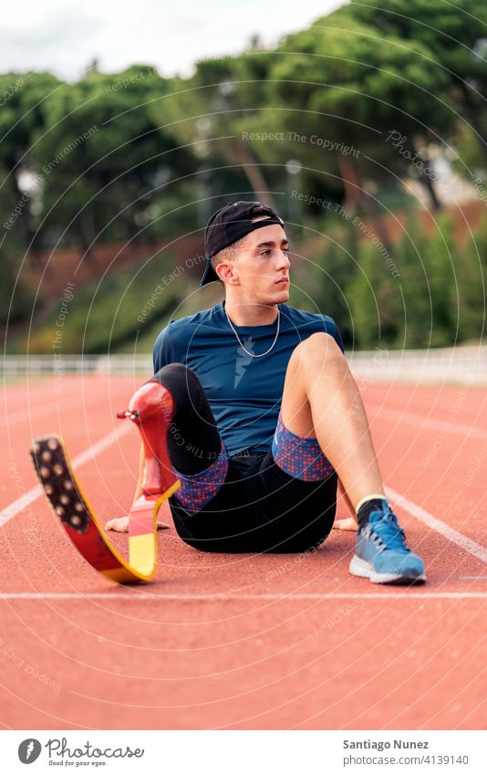 Behinderter Mann Athleten ausruhen Porträt Vorderansicht aussruhen Sitzen Stadion Laufbahn Läufer Sport Prothesen Prothetik Behinderung deaktiviert paralympisch