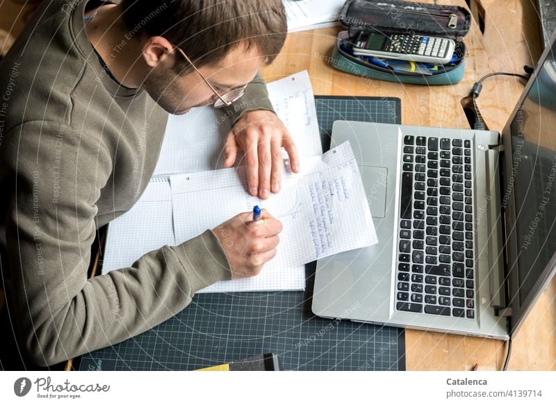 Junger Mann arbeitet am Laptop, online Vorlesung arbeiten zu Hause Homeoffice lernen Internet Portrait Bildung Schreibtisch Fenster Arbeitsplatz Computer