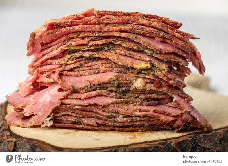 Scheiben vom geschnittenem Pastrami-Fleisch Rindfleisch brisket rustikal FleischScheiben Stapel Nahaufnahme rot Deli schneiden kalt gefaltet dünn geröstet Essen