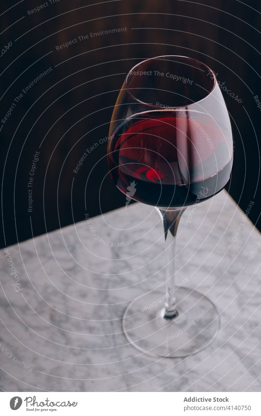 Glas Rotwein auf dem Tisch Weinglas Alkohol Getränk Kristalle Glaswaren trinken lecker Murmel frisch geschmackvoll liquide Geschmack schmackhaft köstlich dienen