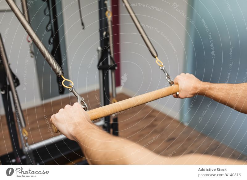 Starker Sportler an der Pilates-Maschine Reformer Training Übung Fitnessstudio passen männlich Athlet hölzern horizontal Bar Zeitgenosse Gesundheit muskulös