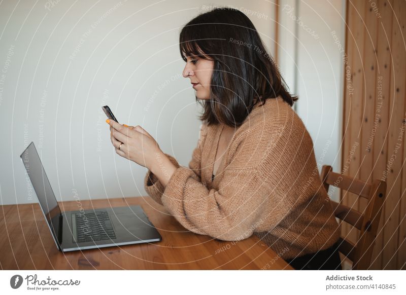 Vielbeschäftigte Unternehmerin beim Surfen auf dem Handy zu Hause Geschäftsfrau Smartphone abgelegen Arbeit benutzend Nachricht Browsen freiberuflich heimwärts