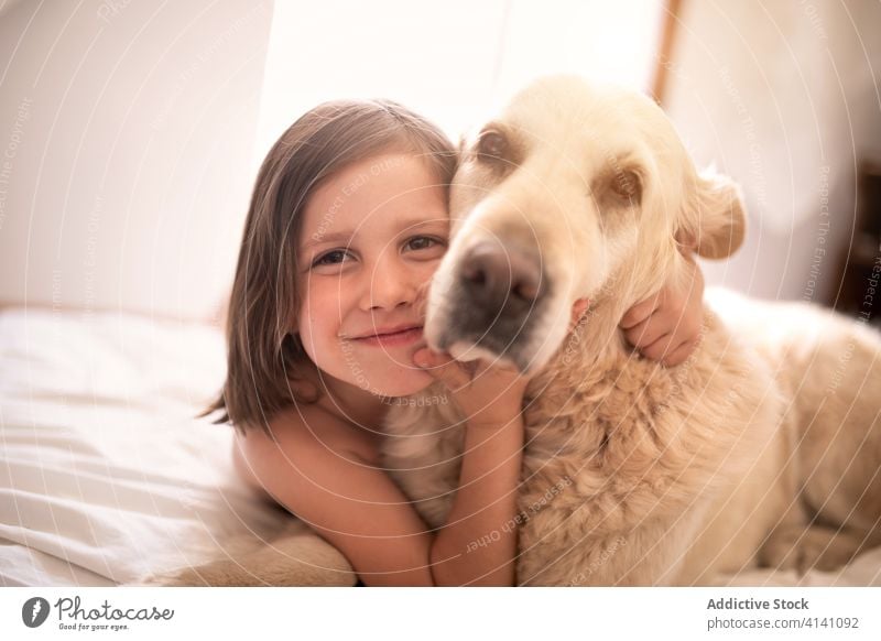 Glückliches Mädchen liegt mit Hund auf zerknittertem Bettlaken ruhen Zuneigung Begleiter Zusammensein idyllisch heimwärts Harmonie Schot hovawart Haustier