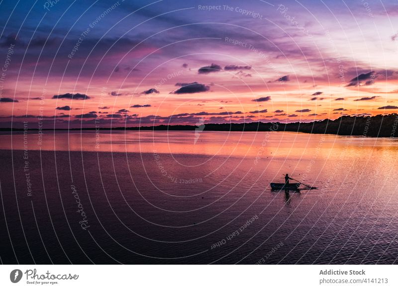 Einsamer Fischer beim Segeln auf ruhigem Wasser im Sonnenuntergang Frieden Himmel Natur Abenddämmerung Mexiko Silhouette einsam Einsamkeit Verkehr Dämmerung