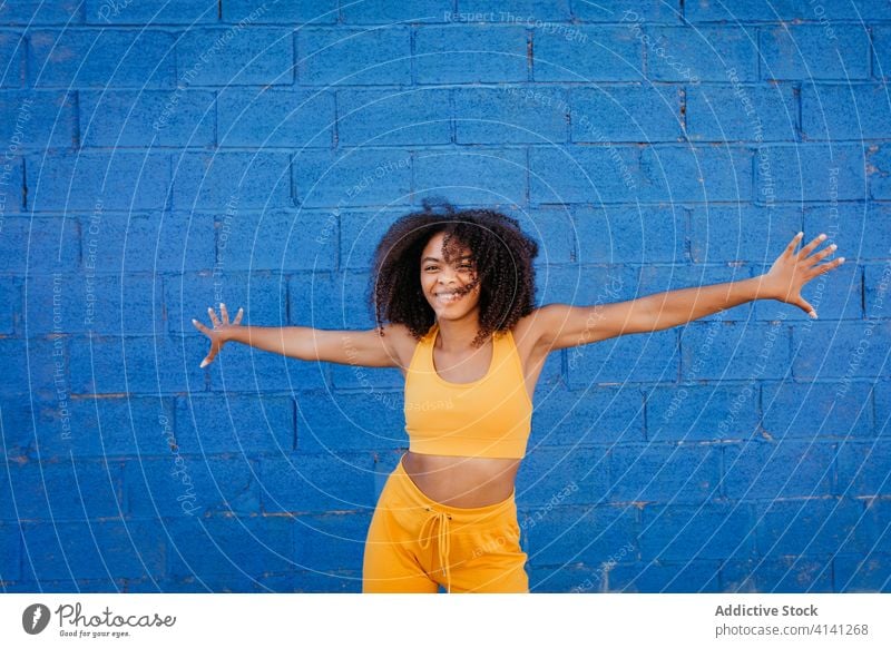 Fröhliche afroamerikanische Frau mit Afro-Frisur in Tanzpose Tanzen Pose sich[Akk] bewegen lebhaft pulsierend heiter Lächeln Bewegung Farbe schwarz ethnisch