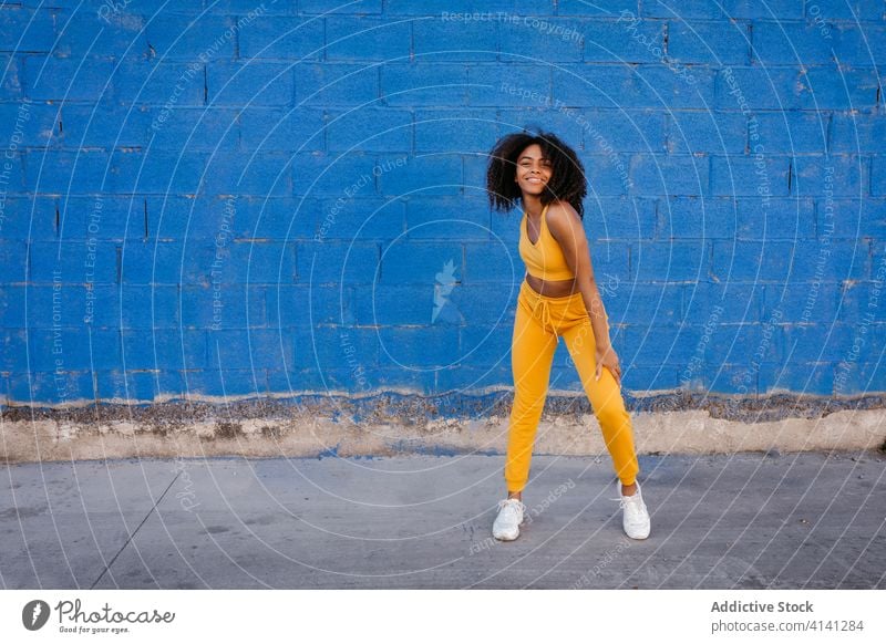 Fröhliche afroamerikanische Frau mit Afro-Frisur in Tanzpose Tanzen Pose sich[Akk] bewegen lebhaft pulsierend heiter Lächeln Bewegung Farbe schwarz ethnisch